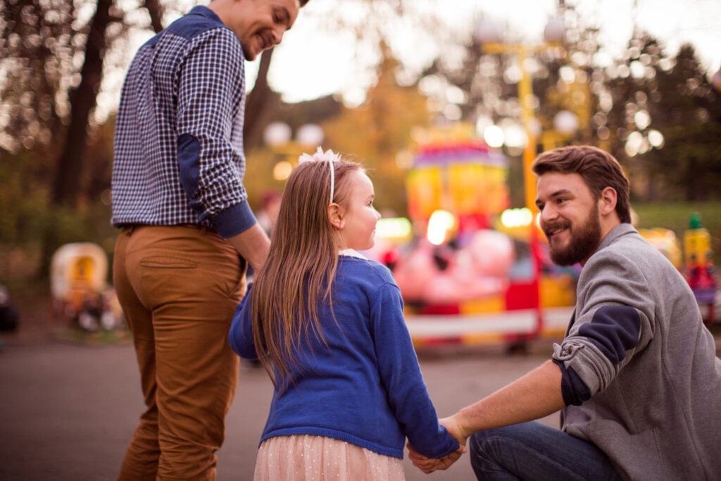 A young girl with her parents at an amusement park