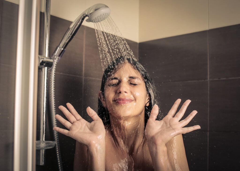 Head-and-shoulders close-up of a woman in a cold shower
