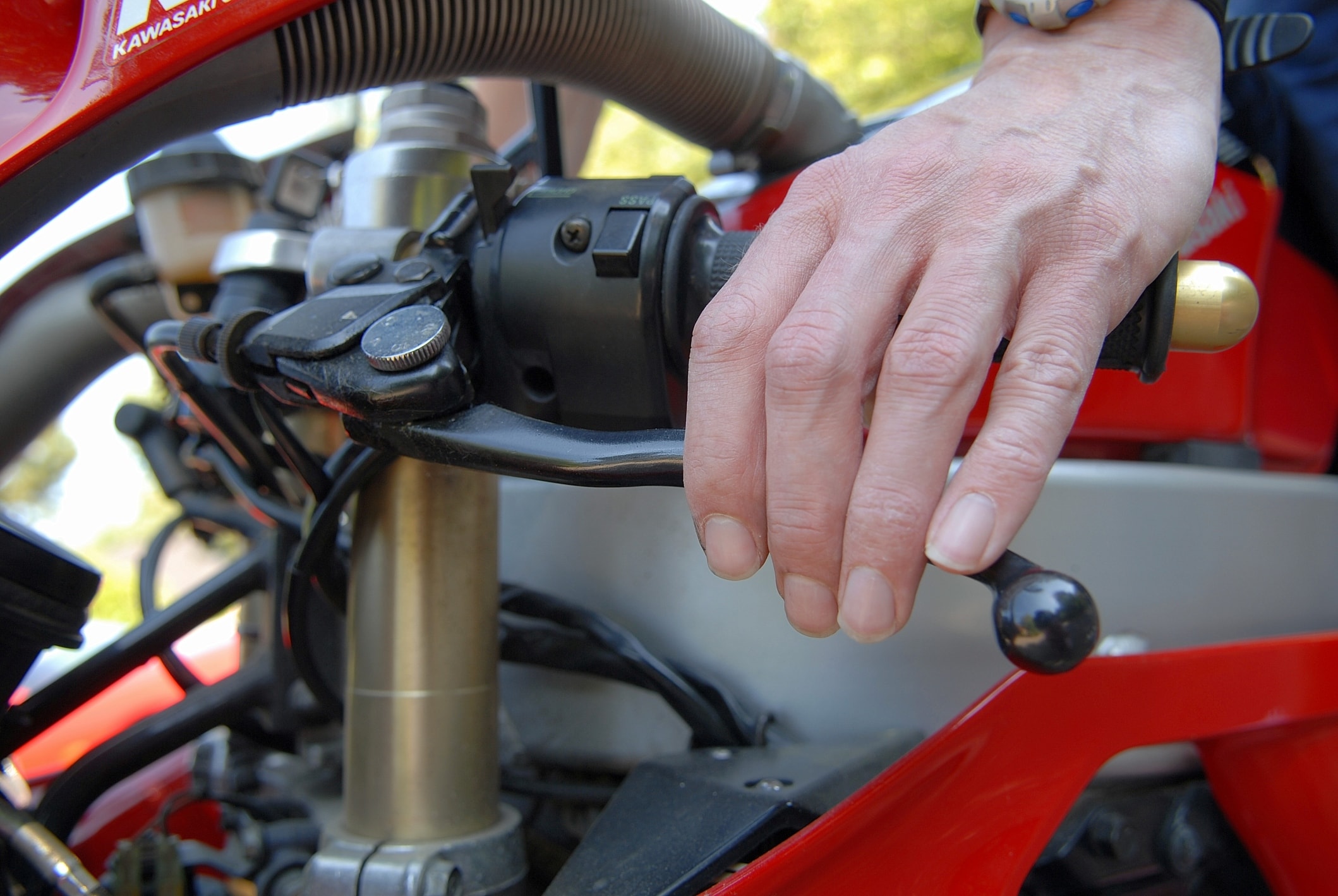 Une main sur le levier de frein d’une moto