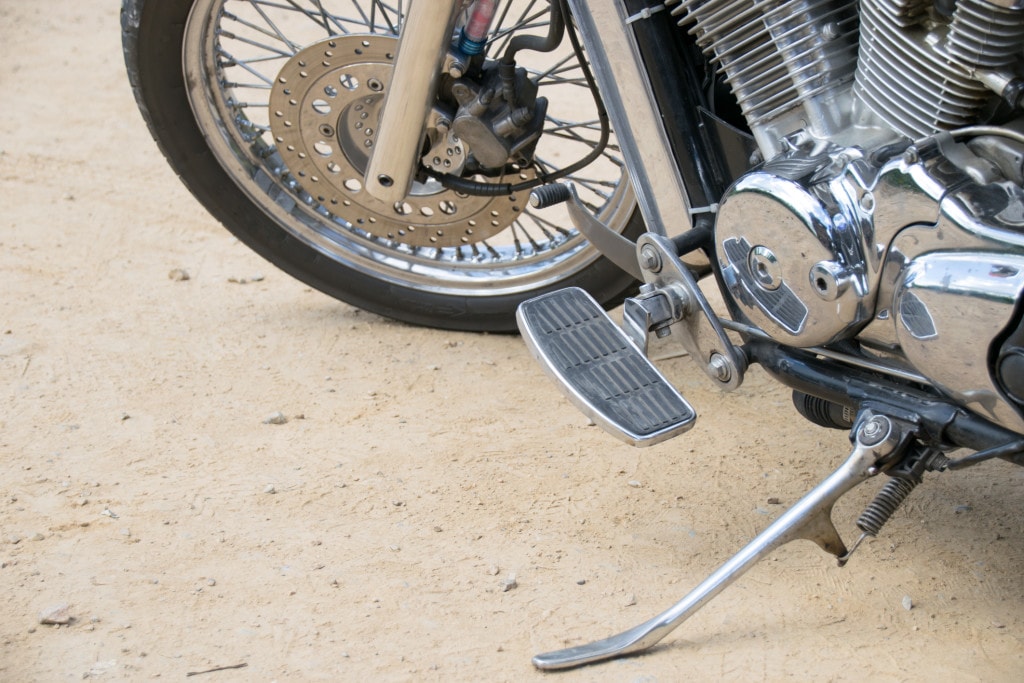 La béquille d’une moto sur un chemin de terre