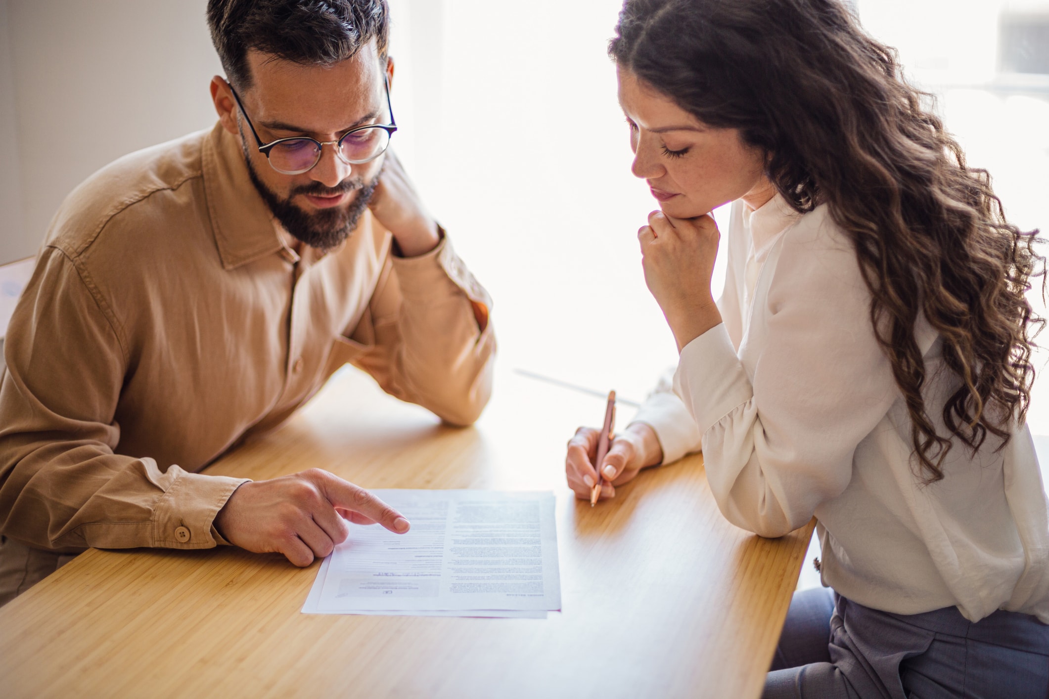 Two people reviewing a document together at a table.