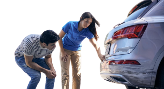a man and woman with a blue shirt accessing the car damage