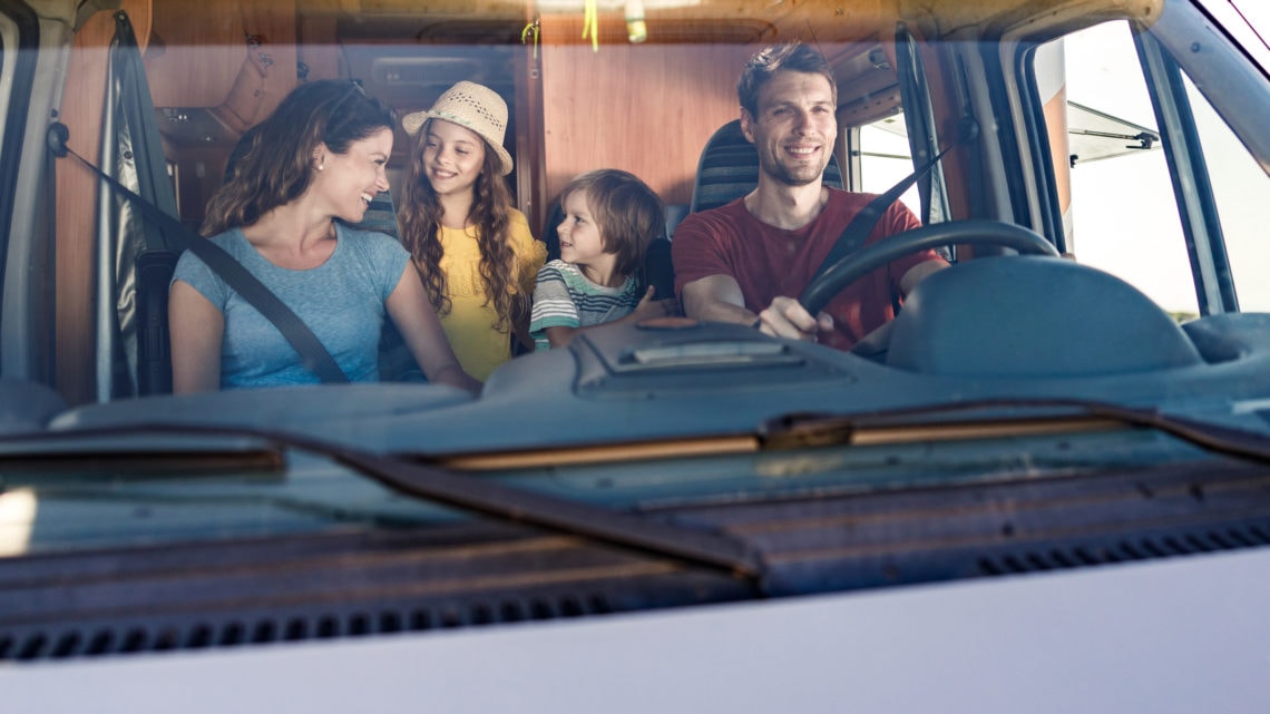 Une famille de quatre personnes à l’avant d’un véhicule récréatif