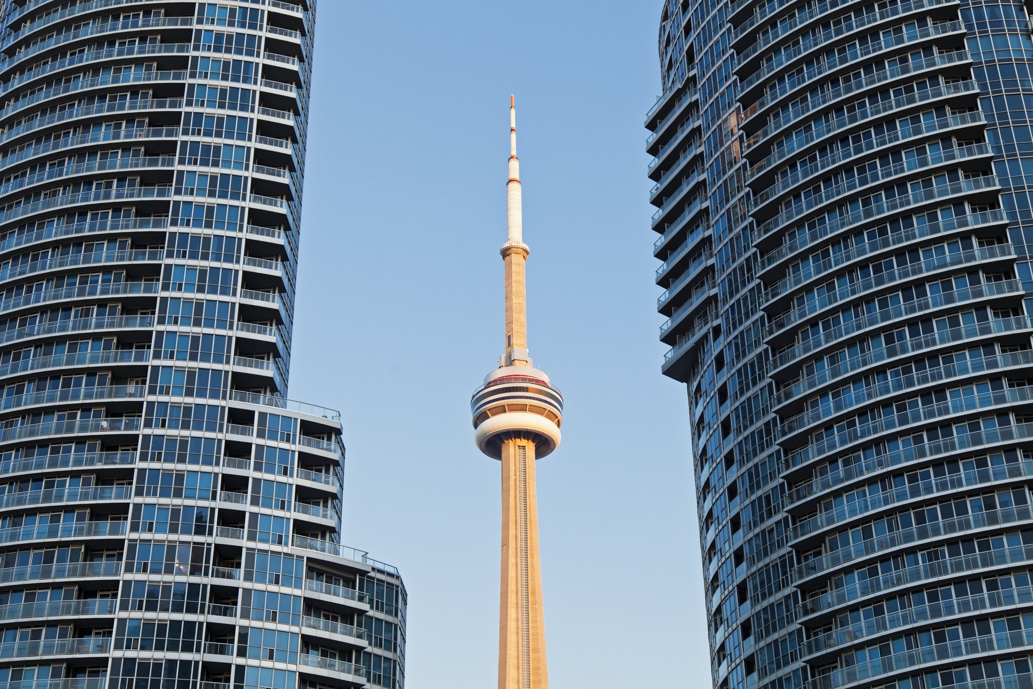 Tour CN encadrée par deux immeubles modernes dans un paysage urbain.