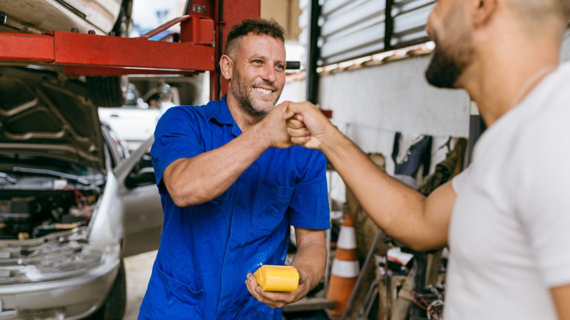 Un mécanicien et un client dans un atelier de réparation automobile