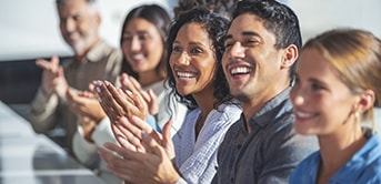 a group of people clapping and smiling