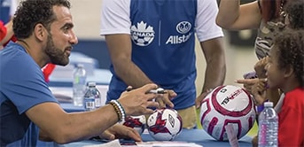 a group of soccer players signing soccer balls