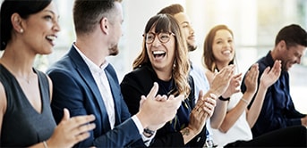 a group of people clapping and smiling