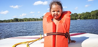 a little girl wearing a life jacket on a boat