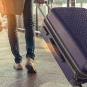 a person walking with a blue suitcase in an airport